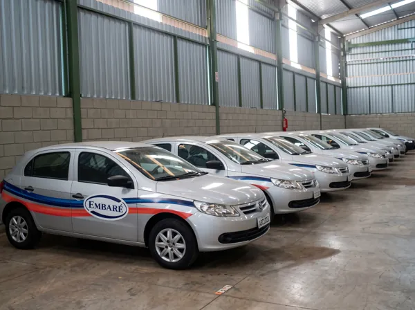 Frota de carros prata com faixas e logo Embaré