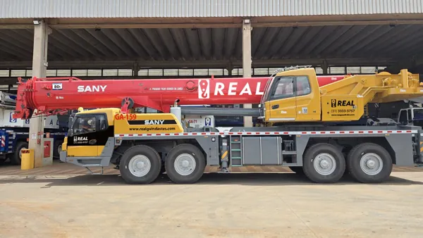 Guindaste Sany vermelho e amarelo com a identidade Real