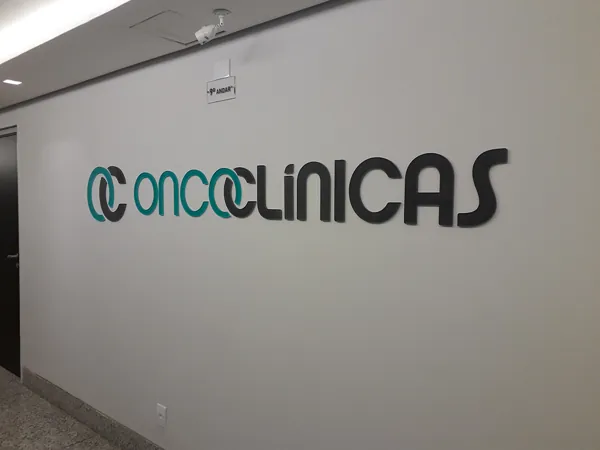 Letreiro Oncoclínicas em relevo em parede de corredor